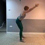 Author doing a spine strength exercise: hip hinge with arm reaches