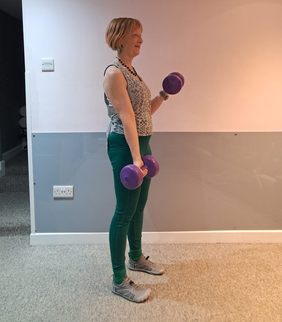 author doing a bicep curl which is an exercise with dumbbells to strengthen the upper arms